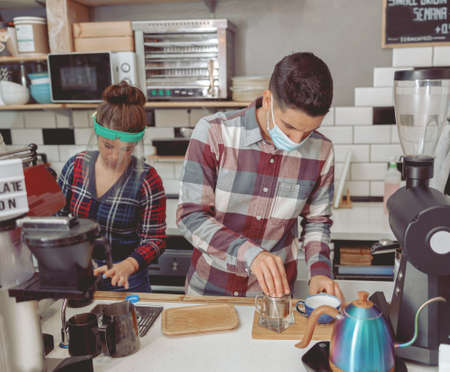 Man and woman barista working in cafe during pandemic