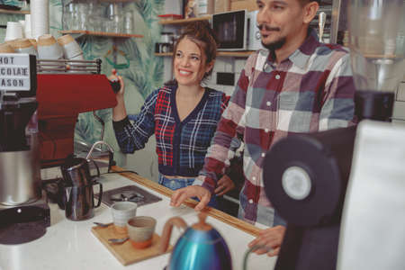 Portrait of smiling man and woman barista accepting orderの写真素材
