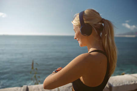 Beautiful athletic woman relaxing outdoors in morningの写真素材