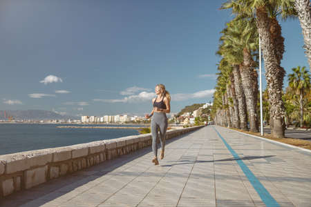 Young athletic woman enjoying exercise near seafrontの写真素材