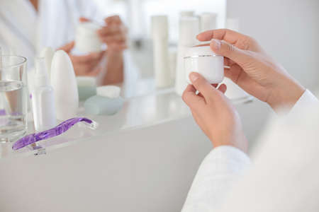Beautiful woman hands opening a jar of creamの写真素材