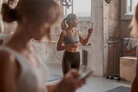 Beautiful female athlete standing in fitness clubの写真素材