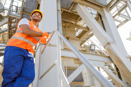 African male engineer inspecting site at construction plantの写真素材