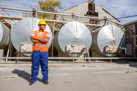Happy African engineer standing at industrial siteの写真素材