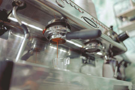 Dripping coffee oils from the filter of the coffee machineの写真素材