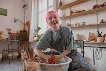 Cute crafter making clay dishes in pottery roomの写真素材