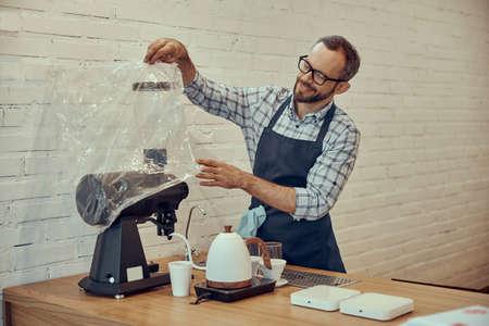 Cheerful bartender preparing coffee machine in cafeの写真素材