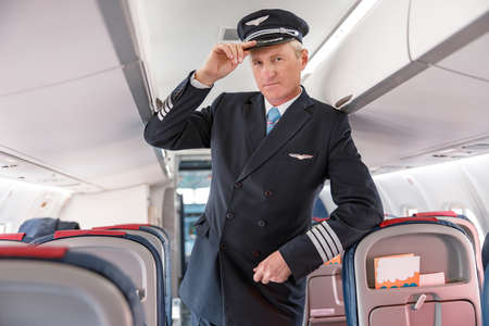 Man airline captain standing in passenger airplane salonの写真素材