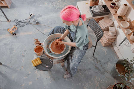 Woman crafter making clay dishes in pottery roomの写真素材