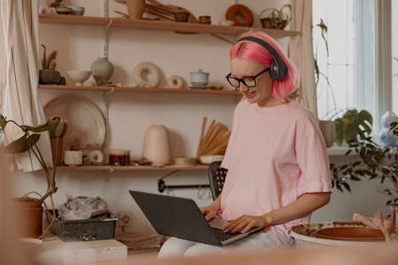 Positive female artisan having ceramics in workshopの写真素材