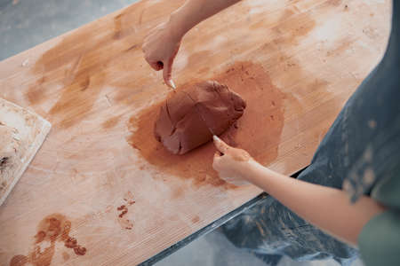 Female pottery artist preparing clay for molding in workroomの写真素材