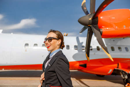 Cheerful women flight attendants walking down airfieldの写真素材