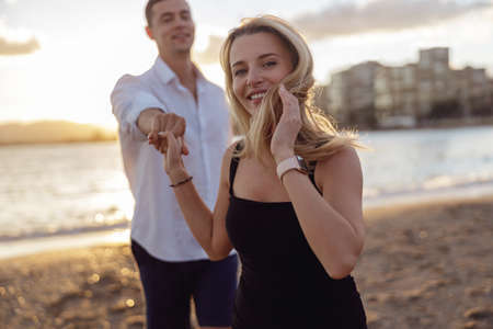 Portrait of beautiful woman holding hand of man standing behind