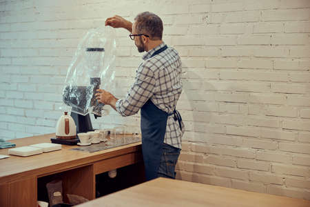 Male bartender preparing coffee machine in cafeの写真素材