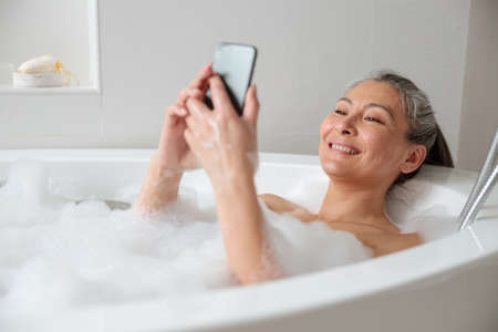 Pretty lady resting in the bathtube after workの写真素材
