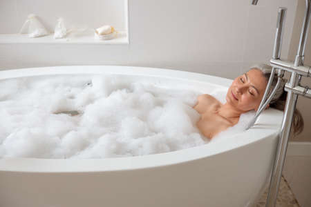 Beautiful adult lady lying in the bathtubeの写真素材