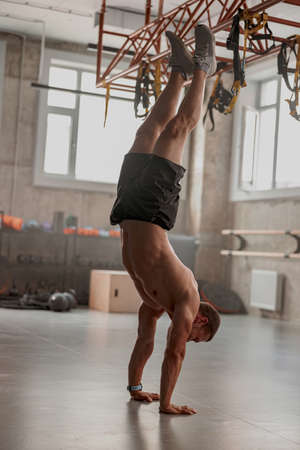 Young man with perfect body training in gymの写真素材
