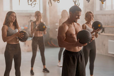 Attractive women exercising with trainer in the gymの写真素材