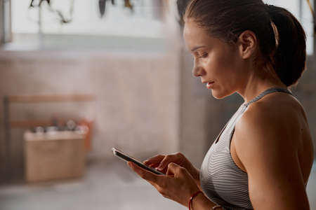 Sportive woman resting after workout at gymの写真素材