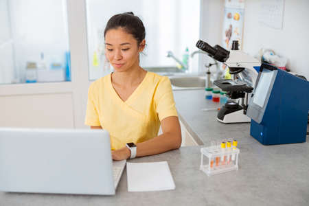 Female vet assistant using laptop in labの写真素材