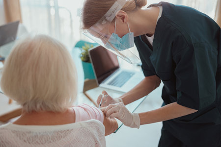 Senior woman visited by district nurse at homeの写真素材