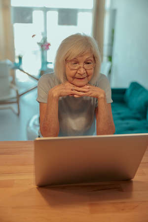 Senior woman resting with laptop at homeの写真素材