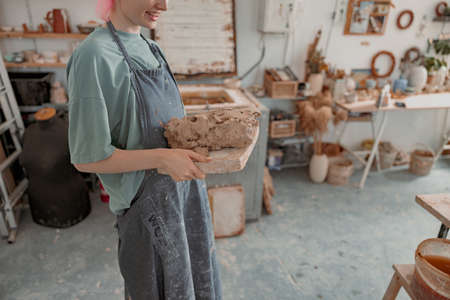 Skillful potter working with clay in workroomの写真素材
