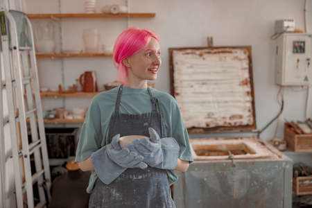 Cute ceramist working with pottery at ceramic workshopの写真素材
