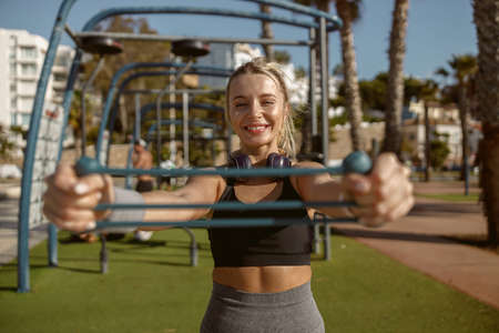 Cheerful woman training with resistance band outdoorsの写真素材