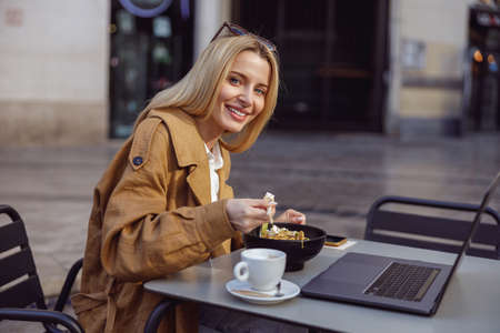 Happy lady enjoying meal in outdoor cafeの写真素材