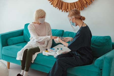 Senior woman visited by district nurse at homeの写真素材