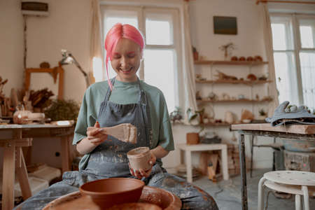 Female potter making earthenware in pottery workshopの写真素材