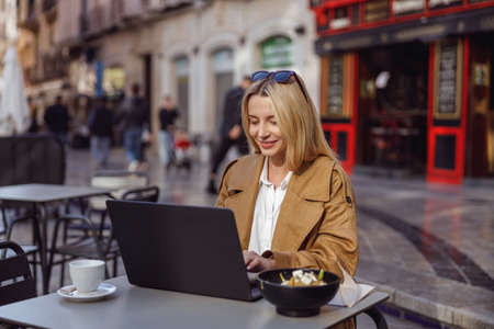Portrait of focused woman working on laptop outdoors