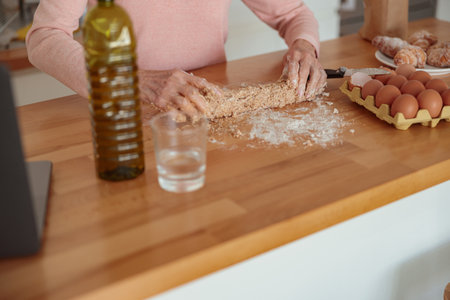 Elderly female molding homemade baking in kitchen