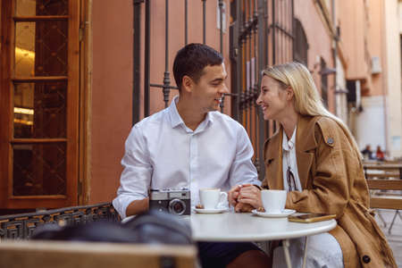 Portrait of lovely couple sitting at outdors cafe and talkingの写真素材