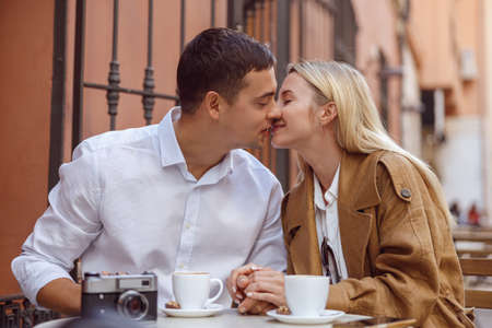Portrait of kissing couple sitting in cafeの写真素材
