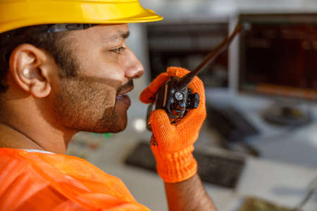 Young multiethnic operator working at construction plant