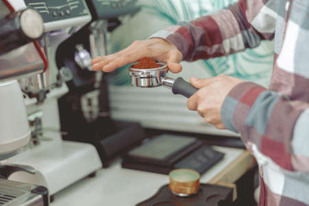 Photo of barista male hands holding filter with ground coffeeの写真素材