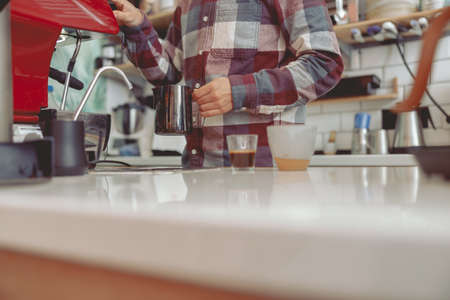 Male barista working near coffee machine in cafe shopの写真素材