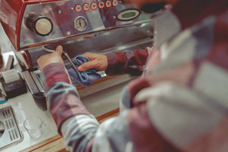 Photo of male hands of barista wiping steam pipeの写真素材