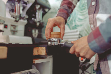 Close up of barista tamping ground coffee for making espressoの写真素材