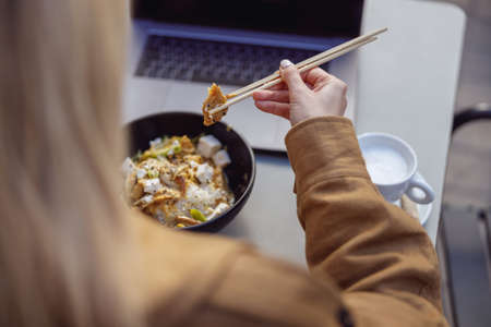 Close-up of woman hands holding food with chopsticksの写真素材