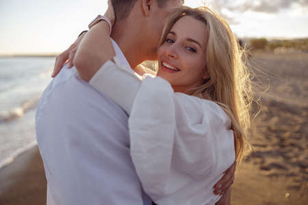 Close-up of beautiful woman hugging man on the beachの写真素材