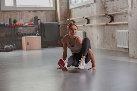 Young fit woman doing fitness exercises at gym