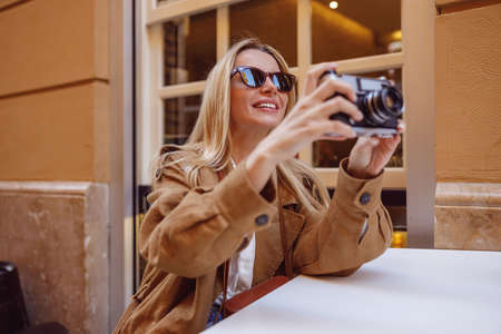 Smiling woman tourist sitting at the table outsideの写真素材
