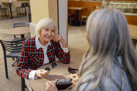Female friends having conversation at street cafeの写真素材