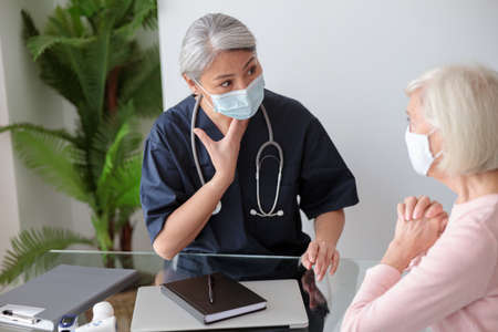 Old woman visited by home care doctorの写真素材