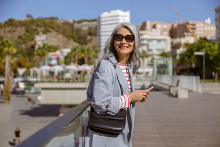 Happy Asian woman smiling while standing outdoorsの写真素材