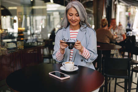 Charming Asian woman having coffee at cafeの写真素材