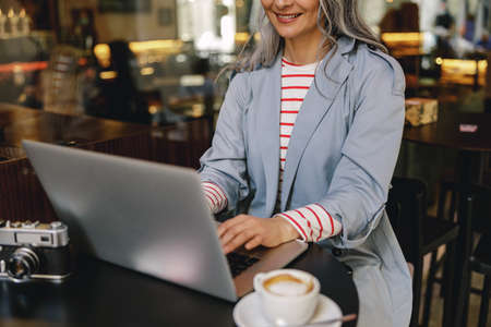 Charming Asian woman having coffee at cafeの写真素材